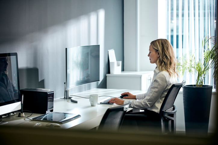 Female office worker using computer in office environment